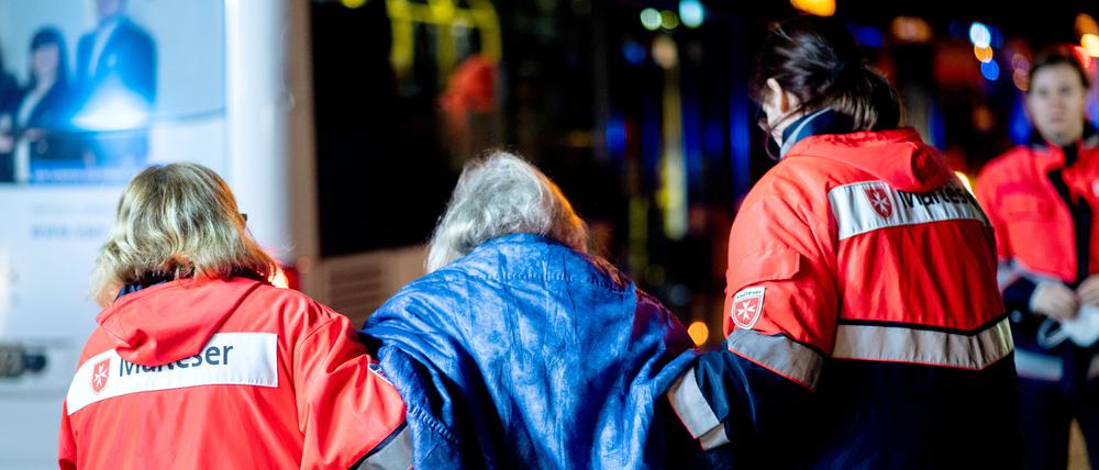 Einsatzsanitäter des Malteser Hilfsdienstes bringen die Bewohner eines Altenheims zu einem Bus, mit dem sie zu einer Notunterkunft gebracht werden sollen.