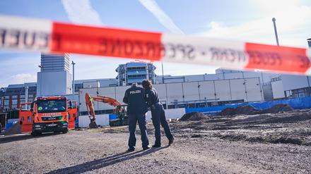 Polizisten stehen hinter einer Absperrung auf der Baustelle in Berlin-Moabit, wo eine Bombe aus dem Zweiten Weltkrieg gefunden wurde.