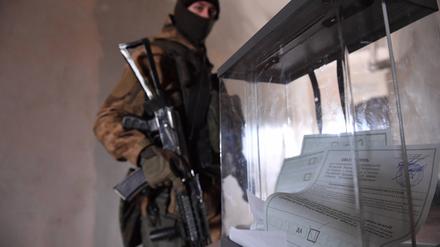 Ein russischer Soldat vor einer Wahlurne in Cherson