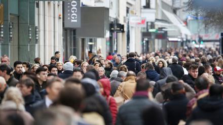 Menschen laufen dicht gedrängt über eine Straße in Düsseldorf. 