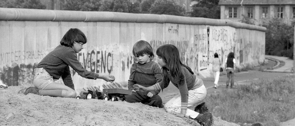 Als die Stadt noch geteilt war: Spielende Kinder vor der Mauer in Kreuzberg. 