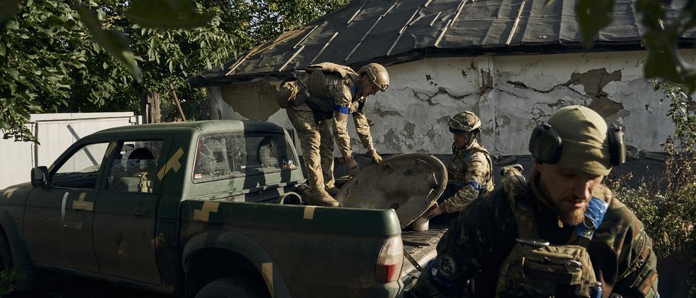 Ukrainische Soldaten entladen Waffenteile in der kürzlich zurückeroberten Stadt Kupjansk.