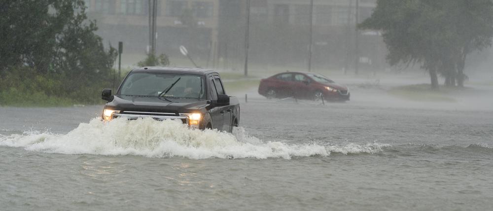 30.09.2022, USA, Charleston: Ein Autofahrer fährt durch Hochwasser, das durch Hurrikan Ian verursacht wurde. Foto: Alex Brandon/AP/dpa +++ dpa-Bildfunk +++