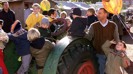 Eltern mit ihren Kindern sitzen auf einem alten Traktor anlässlich des großen Erntedankfestes in der Domäne Dahlem in Berlin. (Archivbild)