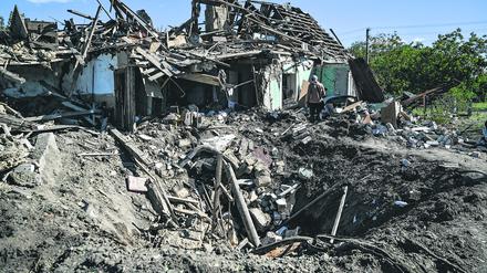 Ein Krater vor einem Haus in Saporischschja, Ukraine, das durch russischen Beschuss zerstört wurde.
