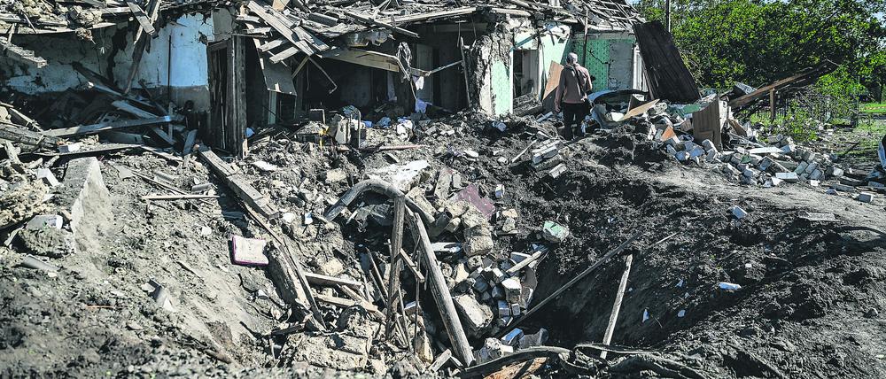 Ein Krater vor einem Haus in Saporischschja, Ukraine, das durch russischen Beschuss zerstört wurde.