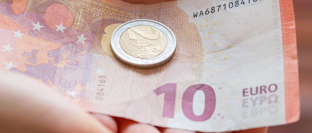 ARCHIV - 10.02.2022, Berlin: Eine Person hält 12 Euro in der Hand. Der gesetzliche Mindestlohn steigt zum 1. Oktober auf 12 Euro je Stunde von zuvor 10,45 Euro. Seit 2015 ist der Mindestlohn damit um mehr als 40 Prozent gestiegen. Foto: Fernando Gutierrez-Juarez/dpa-Zentralbild/dpa +++ dpa-Bildfunk +++