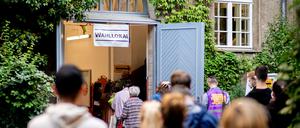 Zahlreiche Wählerinnen und Wähler warten im Berliner Stadtteil Prenzlauer Berg in einer langen Schlange vor einem Wahllokal, das in einer Grundschule untergebracht ist.