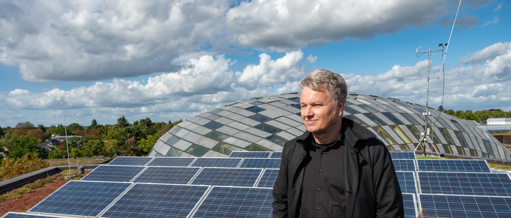 Blick über den Campus. Andreas Wanke auf dem Dach der Rost- und Silberlaube, das mit Solarzellen bestückt ist, im Hintergrund die Kuppel der Philologischen Bibliothek.