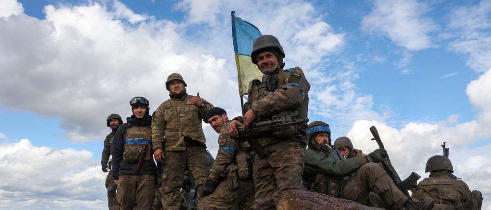 Ukrainian soldiers pose atop a personnel armoured carrier on a road near Lyman, Donetsk region on October 4, 2022, amid the Russian invasion of Ukraine. - Ukraine's President Volodymyr Zelensky said on October 2, 2022 that Lyman, a key town located in one of four Ukrainian regions annexed by Russia, had been "cleared" of Moscow's troops. (Photo by Anatolii Stepanov / AFP)
