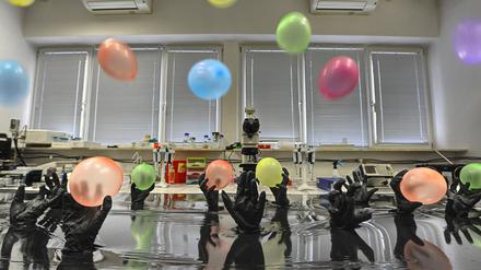 Die polnische Akademie der Wissenschaften zeigt mit diesem Bild das Konzept der Klick-Chemie: Nanopartikel aus Gold, hier die Ballons, werden von Stickstoffschnallen, hier als Hände dargestellt, an eine Kohlenstoffoberfläche, hier Wasser, gebunden.