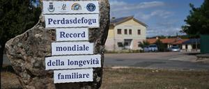 PRODUKTION - 22.09.2022, Italien, Perdasdefogu: Am Ortseingang macht eine steinerne Tafel auf den Rekord aufmerksam. Perdasdefogu ist als Dorf der Hundertjährigen bekannt und hat es damit ins Guinnessbuch der Rekorde geschafft. (zu dpa: «Wo das lange Leben lebt: Dorf der Hundertjährigen auf Sardinien») Foto: Johannes Neudecker/dpa +++ dpa-Bildfunk +++