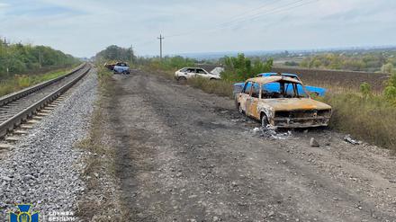 Auf der Straße zwischen Swatowsk und Kupiansk sind zerstörte Autos zu sehen. 