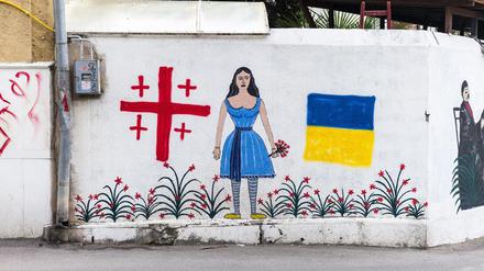 Wandmalerei in Tiflis mit der georgischen und der ukrainischen Flagge. In der Mitte ein Motiv des berühmten georgischen Malers Niko Pirosmani.