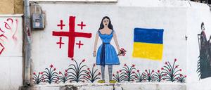 Wandmalerei in Tiflis mit der georgischen und der ukrainischen Flagge. In der Mitte ein Motiv des berühmten georgischen Malers Niko Pirosmani.