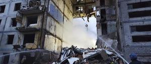Rettungskräfte arbeiten am 9. Oktober 2022 in Saporischschja an einem durch Beschuss beschädigten Gebäude.