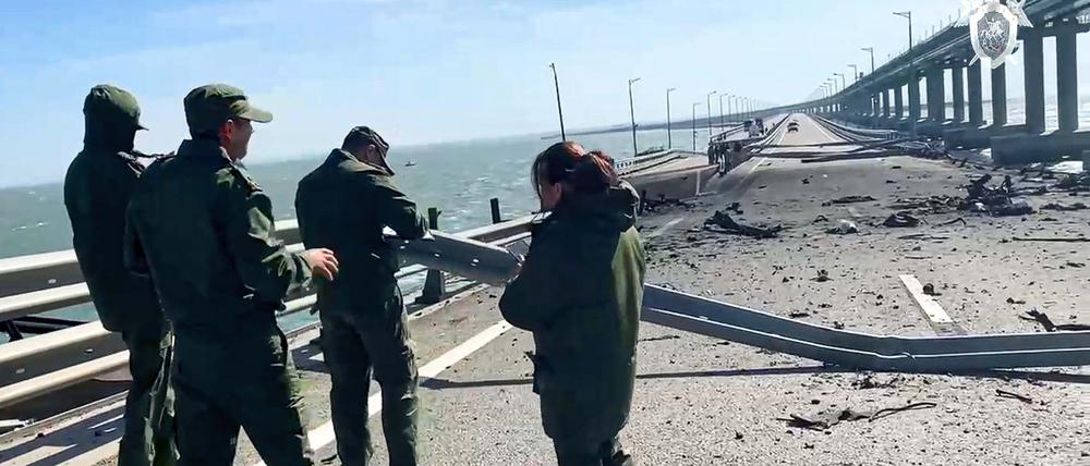 Ein russisches Ermittlungskomitee an einem beschädigten Teil der Krim-Brücke, die das russische Festland und die Halbinsel Krim verbindet.