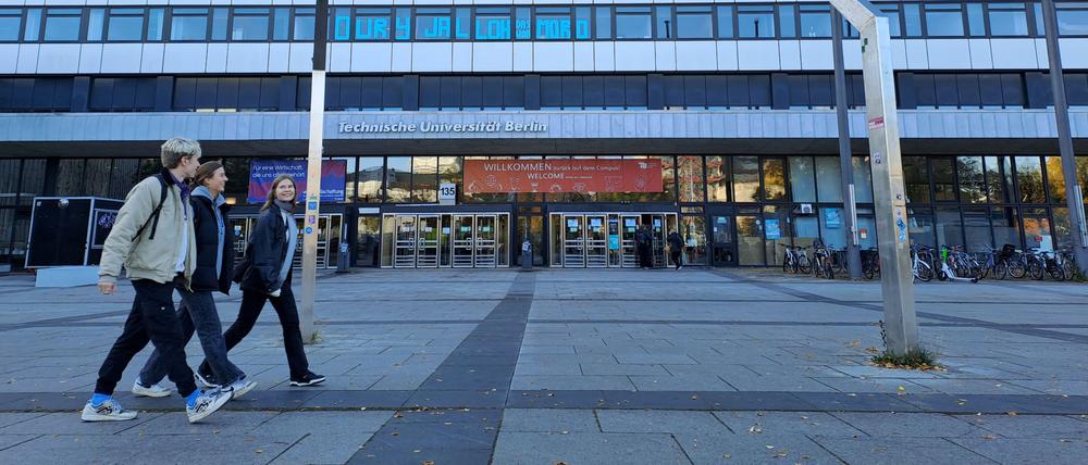 Studierende laufen am 11. Oktober 2022 am Hauptgebäude der TU Berlin entlang. Auf einem Banner über dem Eingang steht: Willkommen zurück auf dem Campus. Am Fahnenmast ist die ukrainische Flagge gehisst.