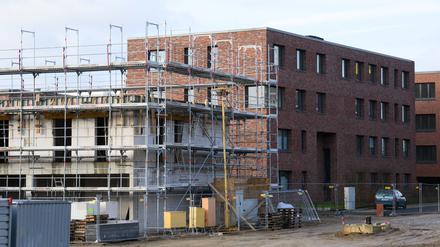 Mehrfamilienhäuser mit Wohnungen werden in einem Neubaugebiet gebaut.