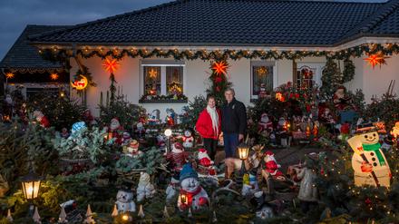 Gisela Liebsch und Gerd Mörl stehen in ihrem weihnachtlich geschmückten Garten im Spreewald. 