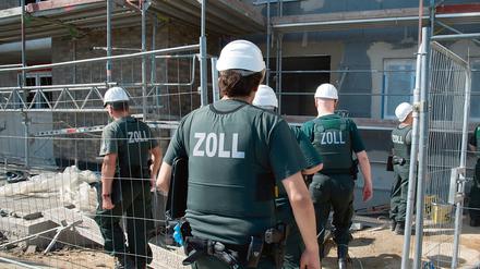 Zollbeamte betreten bei einer Razzia gegen Schwarzarbeit. 