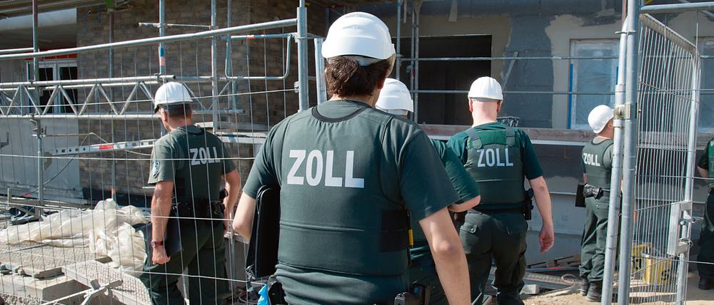 Zollbeamte betreten bei einer Razzia gegen Schwarzarbeit. 