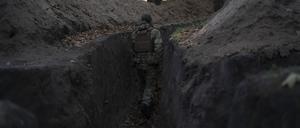 Ein ukrainischer Soldat überprüft die von russischen Soldaten ausgehobenen Schützengräben.
