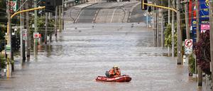 Ein Team des staatlichen Notdienstes von Australien fährt in einem Schlauchboot im Hochwasser einer überschwemmten Straße Victorias.