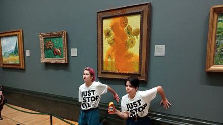 Activists of "Just Stop Oil" glue their hands to the wall after throwing soup at a van Gogh's painting "Sunflowers" at the National Gallery in London, Britain October 14, 2022. Just Stop Oil/Handout via REUTERS    THIS IMAGE HAS BEEN SUPPLIED BY A THIRD PARTY. MANDATORY CREDIT