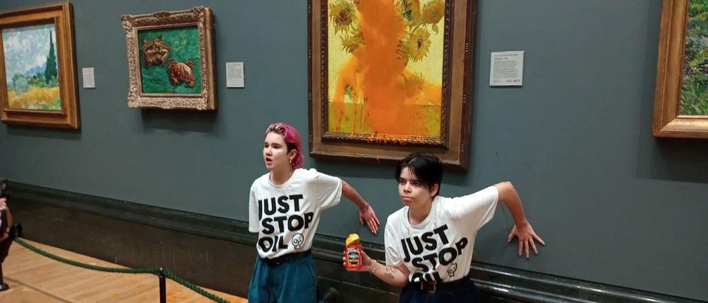 Aktivisten von „Just Stop Oil“ kleben ihre Hände an die Wand, nachdem sie ein Gemälde „Sonnenblumen“ von van Gogh in der National Gallery in London mit Suppe beworfen haben.