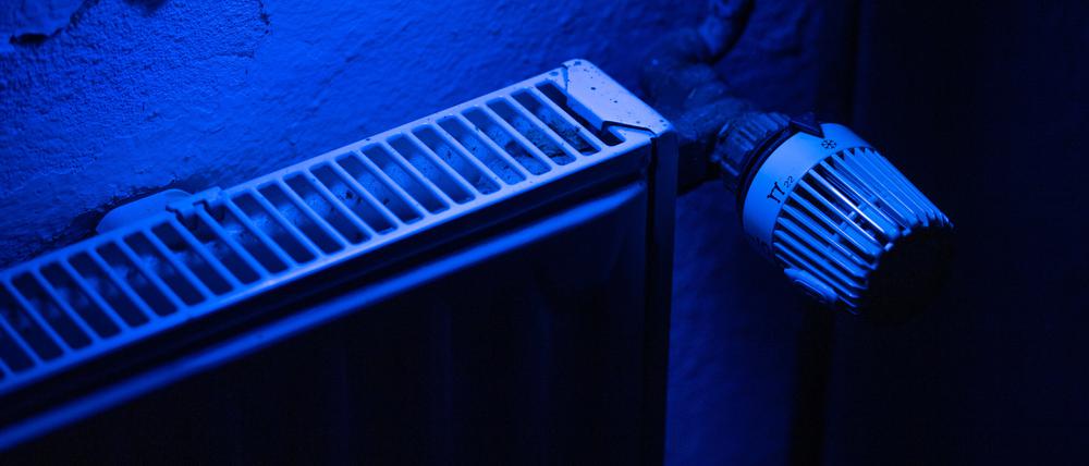ARCHIV - 08.10.2022, Nordrhein-Westfalen, Bad Oeynhausen: ILLUSTRATION - Ein Heizungsthermostat an einem Heizkörper steht auf der kältesten Stufe während es von blauem Licht angeleuchtet wird. Die repräsentative Studie «Die Ängste der Deutschen» wurde am 13.10.2022 in Berlin vorgestellt. Foto: Lino Mirgeler/dpa +++ dpa-Bildfunk +++