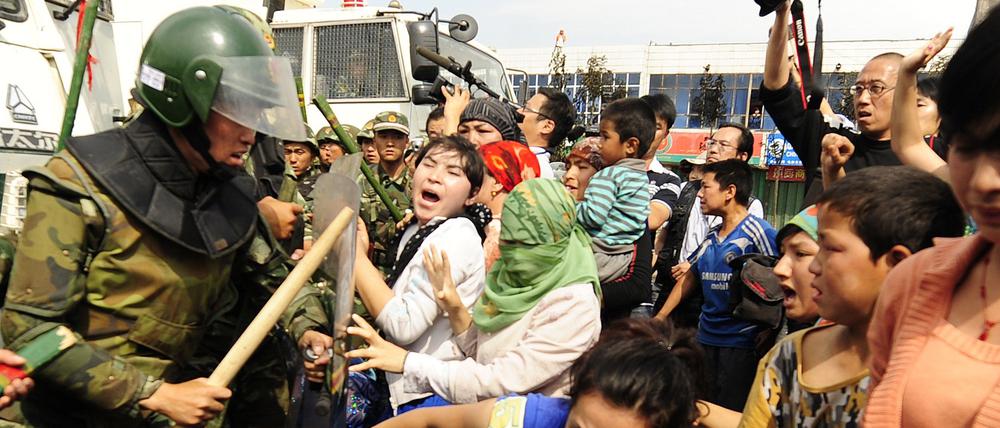 Uiguren in der chinesischen Provinz Xinjiang werden von der Polizei zurückgedrängt (Archivbild). 
