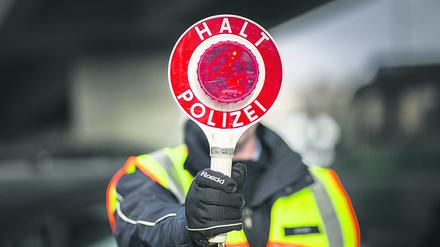  Ein Polizeibeamter haelt eine Polizeikelle im Rahmen einer Verkehrskontrolle in der Hand, Berlin, 27.02.2018. Berlin Deutschland *** A police officer holds a police cell in the context of a traffic control in hand Berlin 27 02 2018 Berlin Germany PUBLICATIONxINxGERxSUIxAUTxONLY Copyright: xFlorianxGaertner/photothek.netx