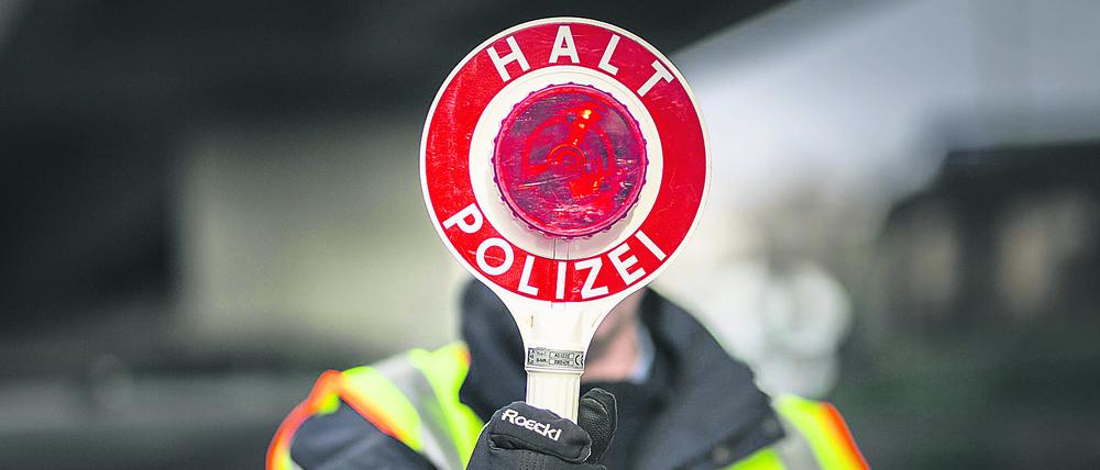  Ein Polizeibeamter haelt eine Polizeikelle im Rahmen einer Verkehrskontrolle in der Hand, Berlin, 27.02.2018. Berlin Deutschland *** A police officer holds a police cell in the context of a traffic control in hand Berlin 27 02 2018 Berlin Germany PUBLICATIONxINxGERxSUIxAUTxONLY Copyright: xFlorianxGaertner/photothek.netx