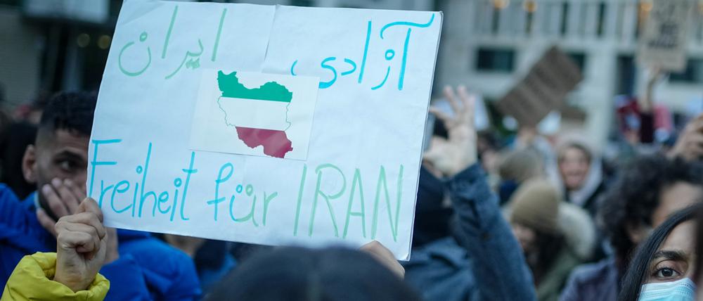28.09.2022, Berlin: Teilnehmer demonstrieren mit Plakaten für Demokratie und Freiheit im Iran am Brandenburger Tor. Foto: Kay Nietfeld/dpa +++ dpa-Bildfunk +++