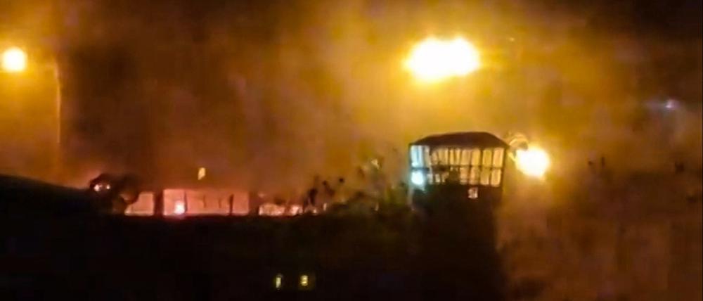 This image grab from a UGC video made available on October 15, 2022, reportedly shows flames and thick smoke rising from the Evin prison, in the northwest of the Iranian capital Tehran. - Cities across Iran have seen protests si