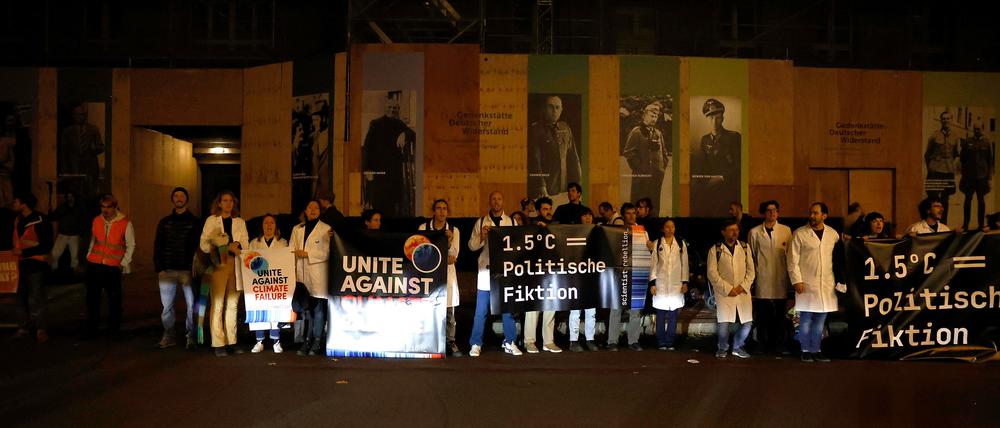 16.10.2022, Berlin: Klimaaktivisten stehen vor dem Hotel, in dem der Weltgesundheitsgipfel stattfindet. Die Teilnehmer forderten ein sofortiges nationales und internationales Handeln gegen eine eskalierende Klimakrise. Die Gruppe Scientist Rebellion bekannte sich zu der Aktion. Foto: Carsten Koall/dpa +++ dpa-Bildfunk +++