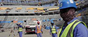 Bauarbeiter arbeiten am Lusail-Stadion, einem der Stadien der WM 2022. 