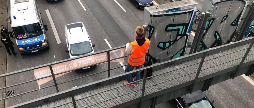 Klimaaktivist auf einer Schilderbrücke der Berliner Stadtautobahn.
