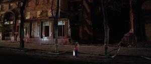 Passanten betrachten ein beschädigtes Gebäude in der ukrainischen Stadt Saporischschja.