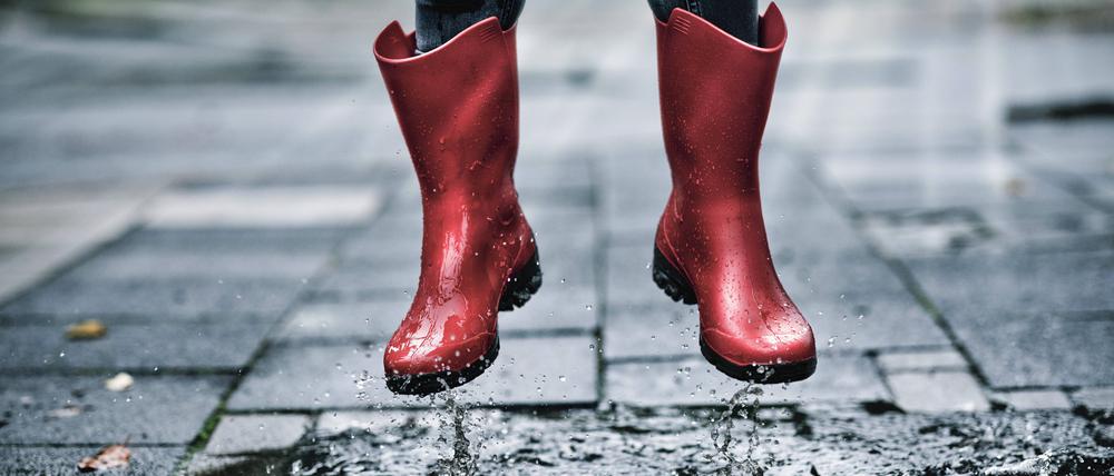 Feet of little girl wearing rubber boots jumping over small puddle model released Symbolfoto FLLF00518