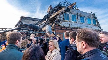 Nancy Faeser (SPD), Bundesinnenministerin, spricht vor dem abgebrannten Hotel mit Andrej Bondartschuk, einem Betreuer der Einrichtung und Augenzeuge des Feuers.