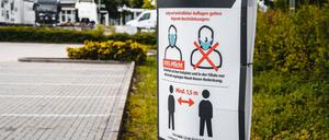 Eine Aufforderung zum Tragen einer Maske ist an einer Straße in Bayern zu sehen.