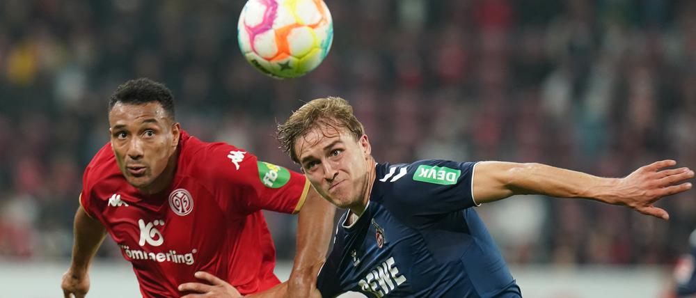 21.10.2022, Rheinland-Pfalz, Mainz: Fußball: Bundesliga, FSV Mainz 05 - 1. FC Köln, 11. Spieltag, Mewa Arena. Der Kölner Timo Hubers (r) und der Mainzer Karim Onisiwo kämpfen um den Ball. Foto: Thomas Frey/dpa - WICHTIGER HINWEIS: Gemäß den Vorgaben der DFL Deutsche Fußball Liga bzw. des DFB Deutscher Fußball-Bund ist es untersagt, in dem Stadion und/oder vom Spiel angefertigte Fotoaufnahmen in Form von Sequenzbildern und/oder videoähnlichen Fotostrecken zu verwerten bzw. verwerten zu lassen. +++ dpa-Bildfunk +++