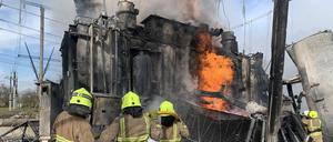Ukrainische Feuerwehrleute löschen getroffene Stromnetz-Infrastruktur in der Region Riwne.