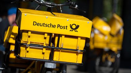 Ein Fahrrad von der Deutschen Post steht an einer Straße. 