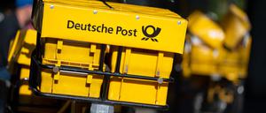 Ein Fahrrad von der Deutschen Post steht an einer Straße.
