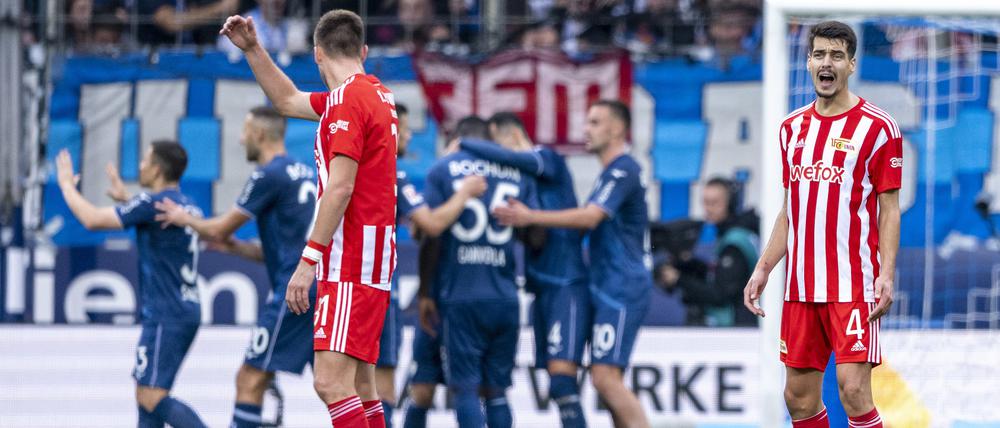 Berlins Diogo Leite (r) ärgert sich nach dem 2:0, während im Hintergrund die Bochumer Spieler Jubeln. Foto: David Inderlied/dpa -