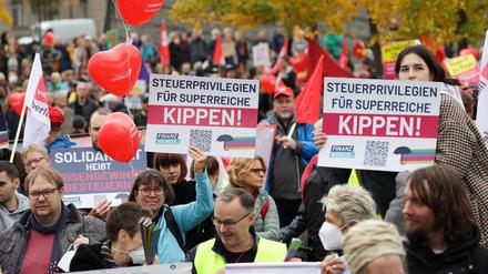 Transparente mit der Aufschrift „Steuerprivilegien für Superreiche kippen!“ sind im Invalidenpark bei einer Demonstration zu sehen. 