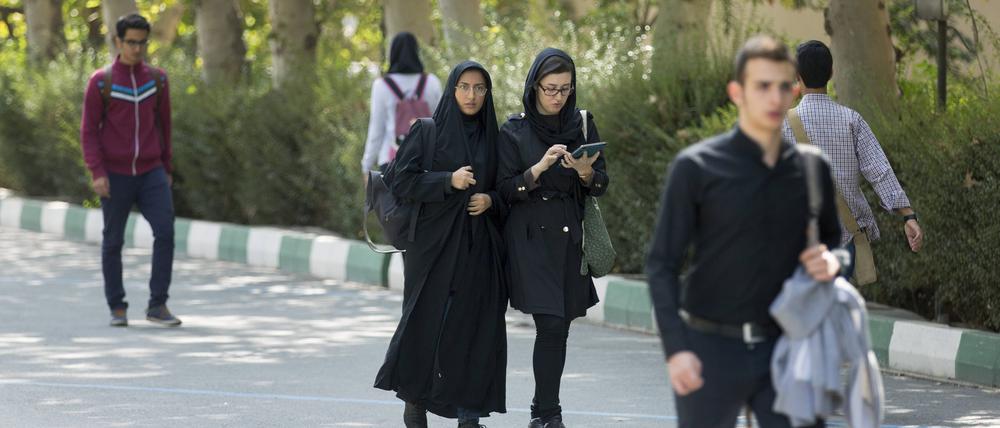 Studentinnen und Studenten laufen an der Universitaet in Teheran am 18. Oktober 2015 über den Campus.